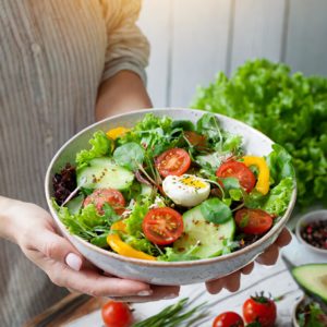 Frau hält Schüssel voll mit gesundem Salat